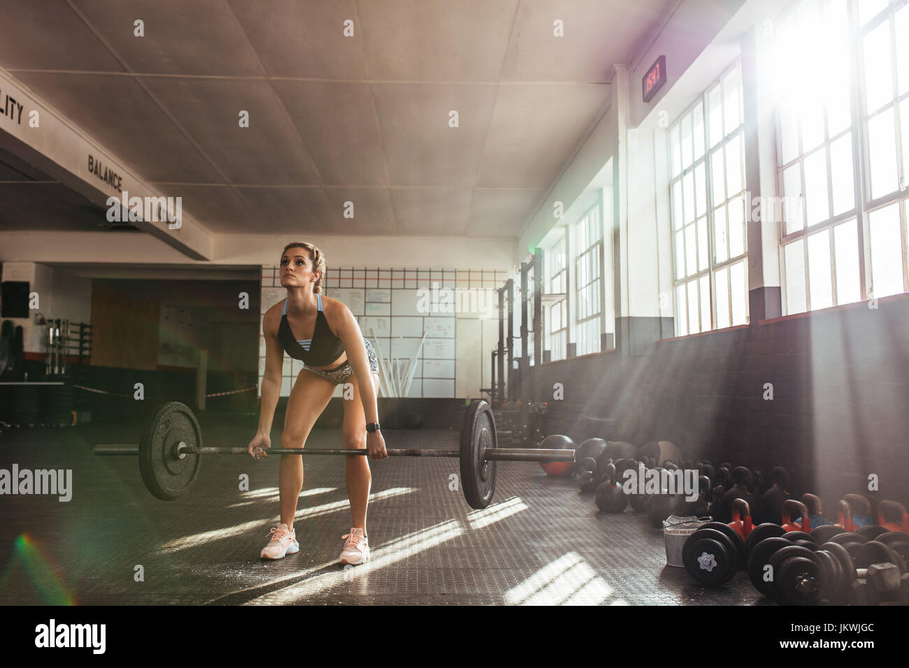 Les poids lourds de levage femme à la salle de sport pour l'entraînement musculaire. L'exercice de l'athlète à l'aide d'une barre d'haltères. Banque D'Images