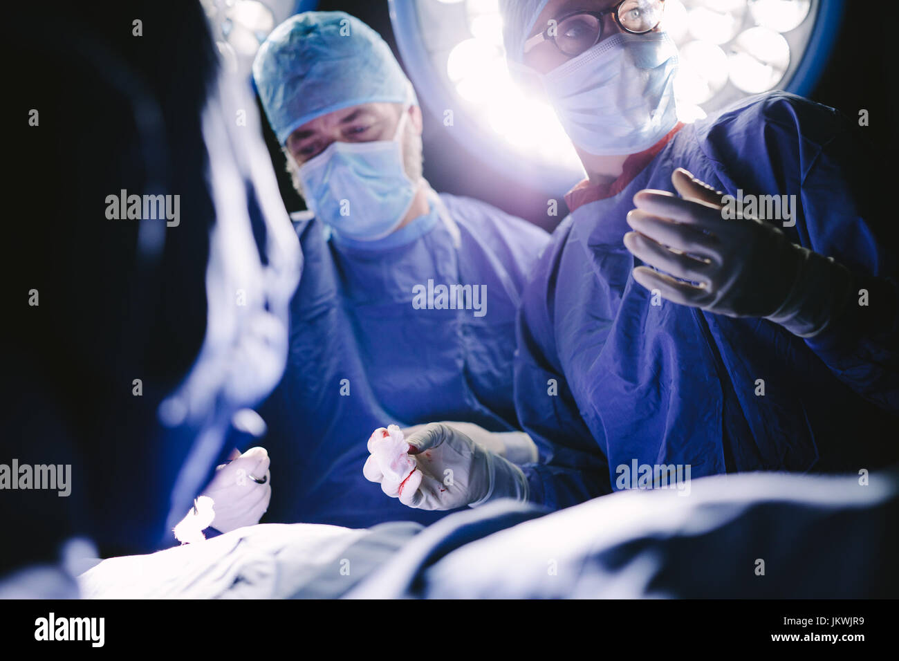 Les professionnels de la santé pendant la chirurgie salle d'opération. Groupe des chirurgiens en salle d'opération de l'hôpital. Banque D'Images