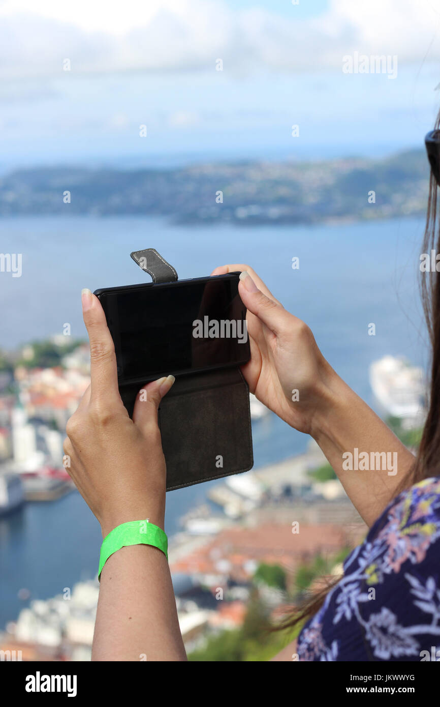 Photos de téléphone mobile - female tourist utilise mobile pour capturer paysages de Bergen, Norvège Banque D'Images