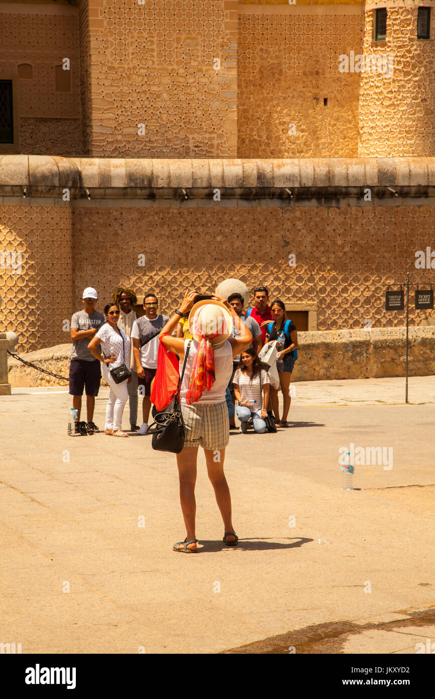 Femme de prendre une photo d'un groupe de touristes dans la ville espagnole de Barcelone en face de l'Alcazar castle Banque D'Images