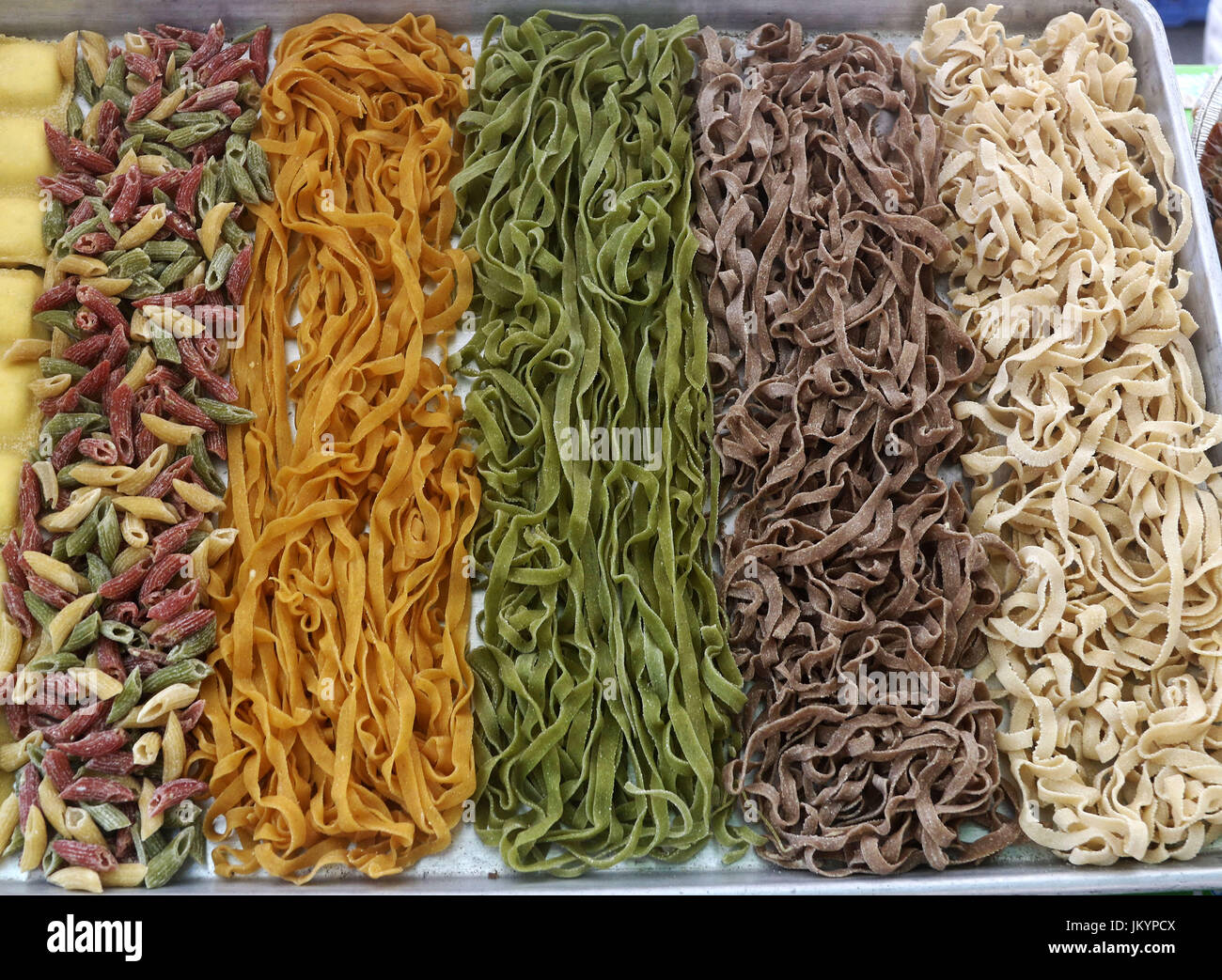 Non cuites fraîches pâtes fettuccine penne et colorés dans un bac Banque D'Images