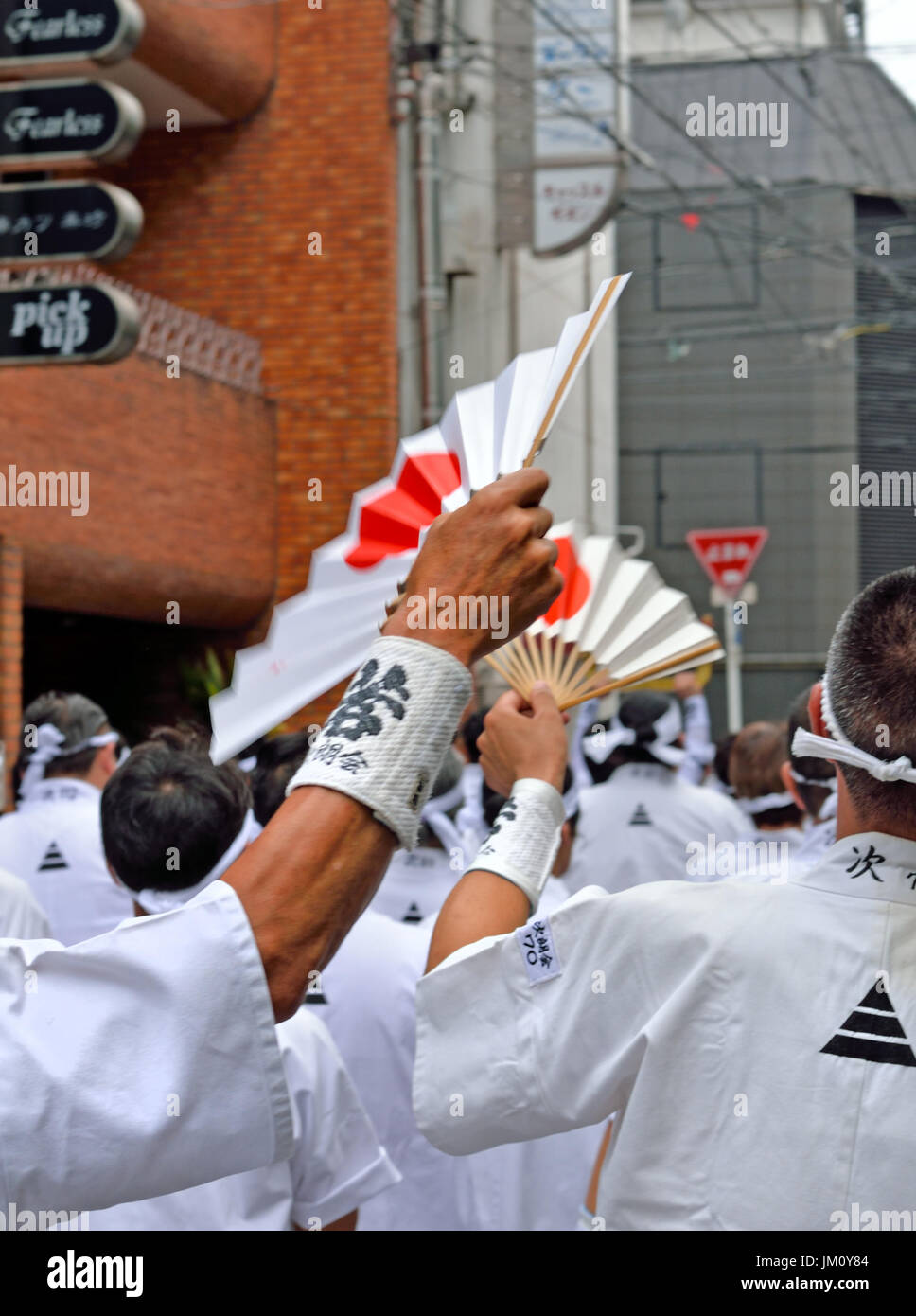 KYOTO, JAPON - 24 juillet 2017 : deux hommes avec l'augmentation des fans de l'onde soleils sur eux lorsqu'ils défilent à Kyoto, au Japon en tant que partie de la Gion Matsuri Banque D'Images