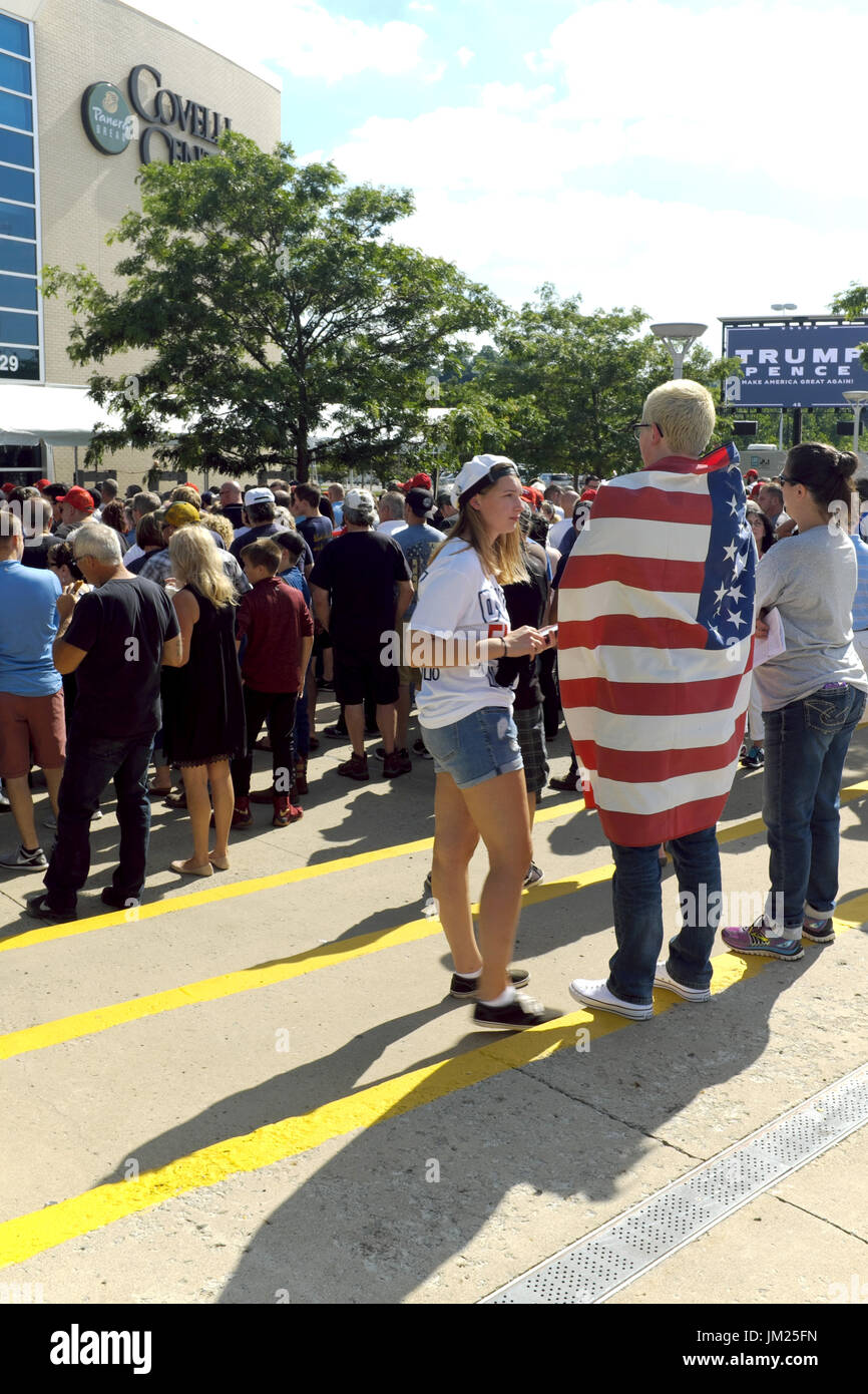 Youngstown, Ohio, USA. Le 25 juillet, 2017. L'homme enveloppé dans un drapeau USA avec des amis à l'extérieur de l'Covelli Centre à Youngstown, Ohio pour le président Trump rally le 25 juillet 2017 Crédit : Mark Kanning/Alamy Live News Banque D'Images