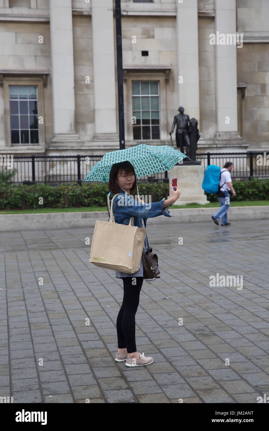 London,UK,26 Juillet 2017,l'humide et sombre en général la température n'est pas dissuader les visiteurs et les touristes à Trafalgar Square, Londres©Keith Larby/Alamy Live News Banque D'Images