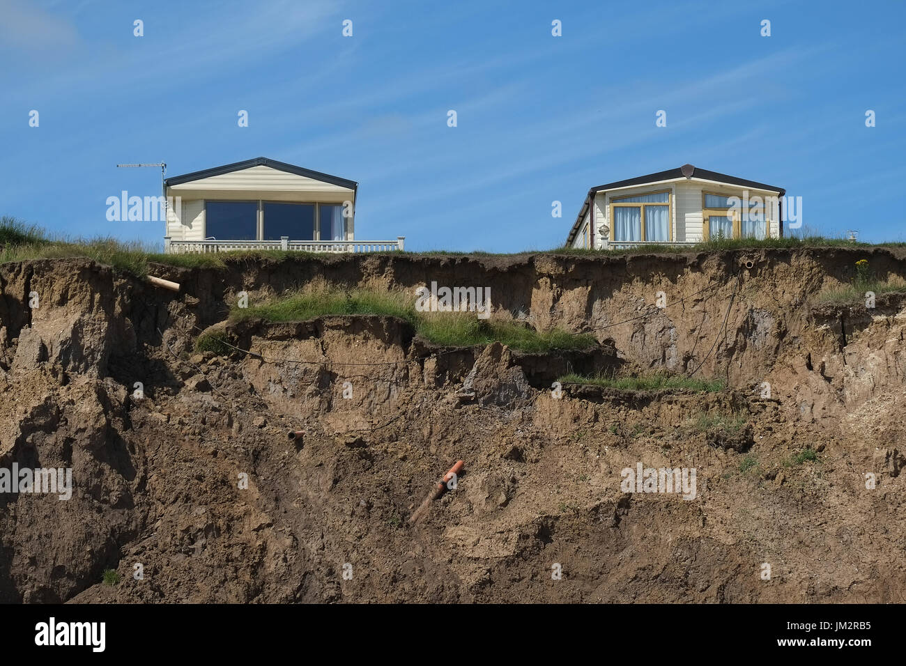 Grande maison de vacances caravanes statiques sur le bord de l'érosion rapide de falaises d'argile sur la côte est du Yorkshire, UK. Banque D'Images