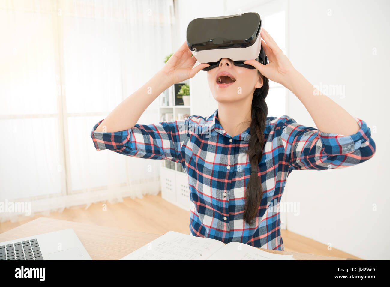 Close up of student holding VR-équipement casque et profiter de l'innovation en ligne jeu vidéo 3D Réalité virtuelle incroyable sentiment assis au bureau Banque D'Images
