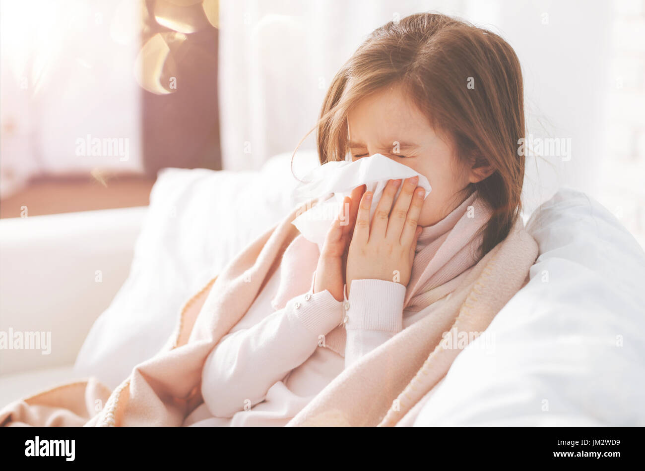 Enfant malsain assis à la maison sur le canapé Banque D'Images