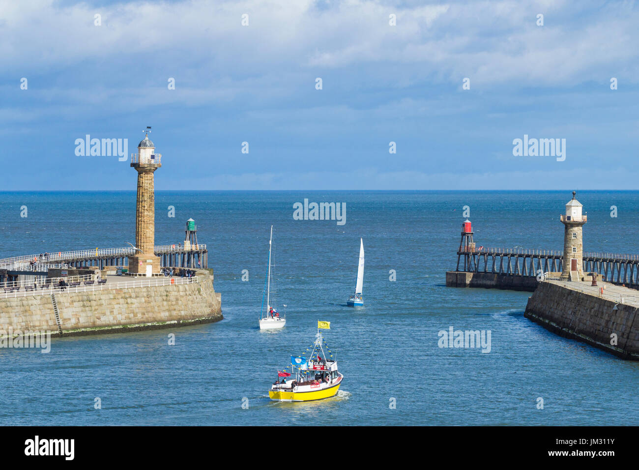 Bateau de tourisme de voile entre les jetées du port à Whitby, North yorlshire, Angleterre Royaume-Uni. Banque D'Images