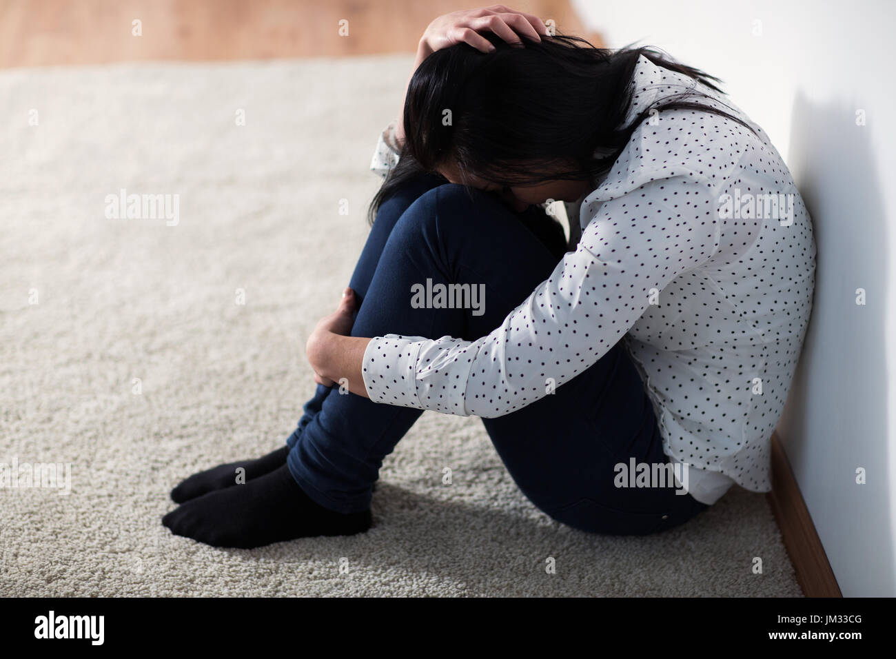 Femme malheureuse pleurer sur le plancher à la maison Banque D'Images