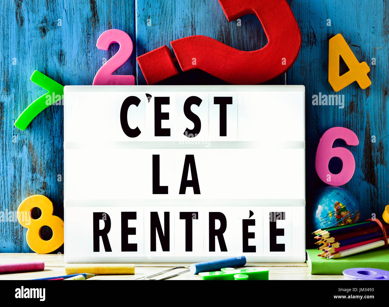 Le texte cest la rentrée, le retour à l'école en français, dans une lightbox sur un fond de bois rustique, entouré d'un nombre à trois dimensions Banque D'Images