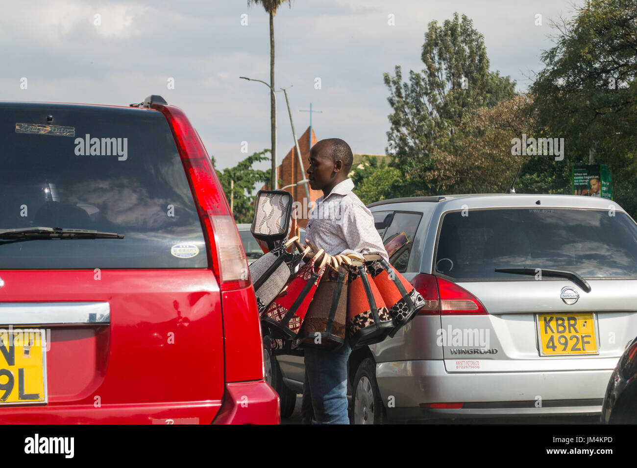 Un homme qui offre des sacs à main pour la vente aux conducteurs dans les embouteillages sur l'autoroute Uhuru à Nairobi, Kenya Banque D'Images