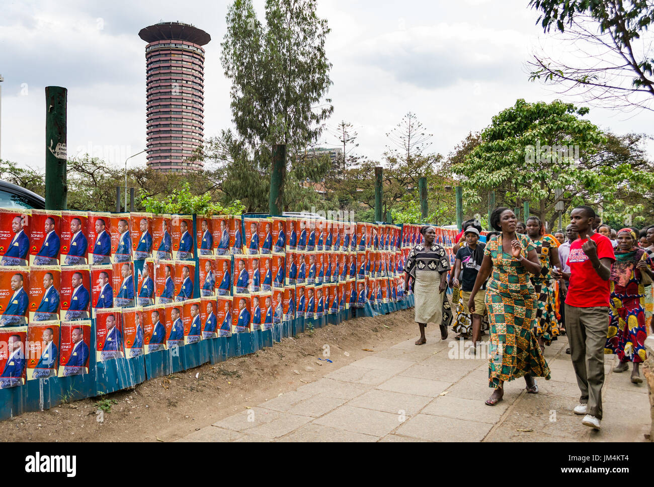 Les gens en passant devant les affiches des candidats à l'élection du Kenya à Nairobi sur le mur avec la Ville Dubai International Convention Centre en arrière-plan, au Kenya Banque D'Images