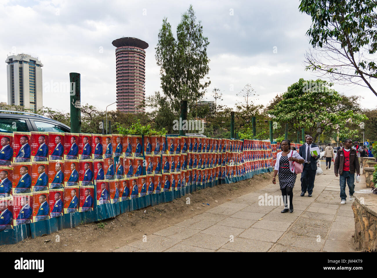 Les gens en passant devant les affiches des candidats à l'élection du Kenya à Nairobi sur le mur avec la Ville Dubai International Convention Centre en arrière-plan, au Kenya Banque D'Images