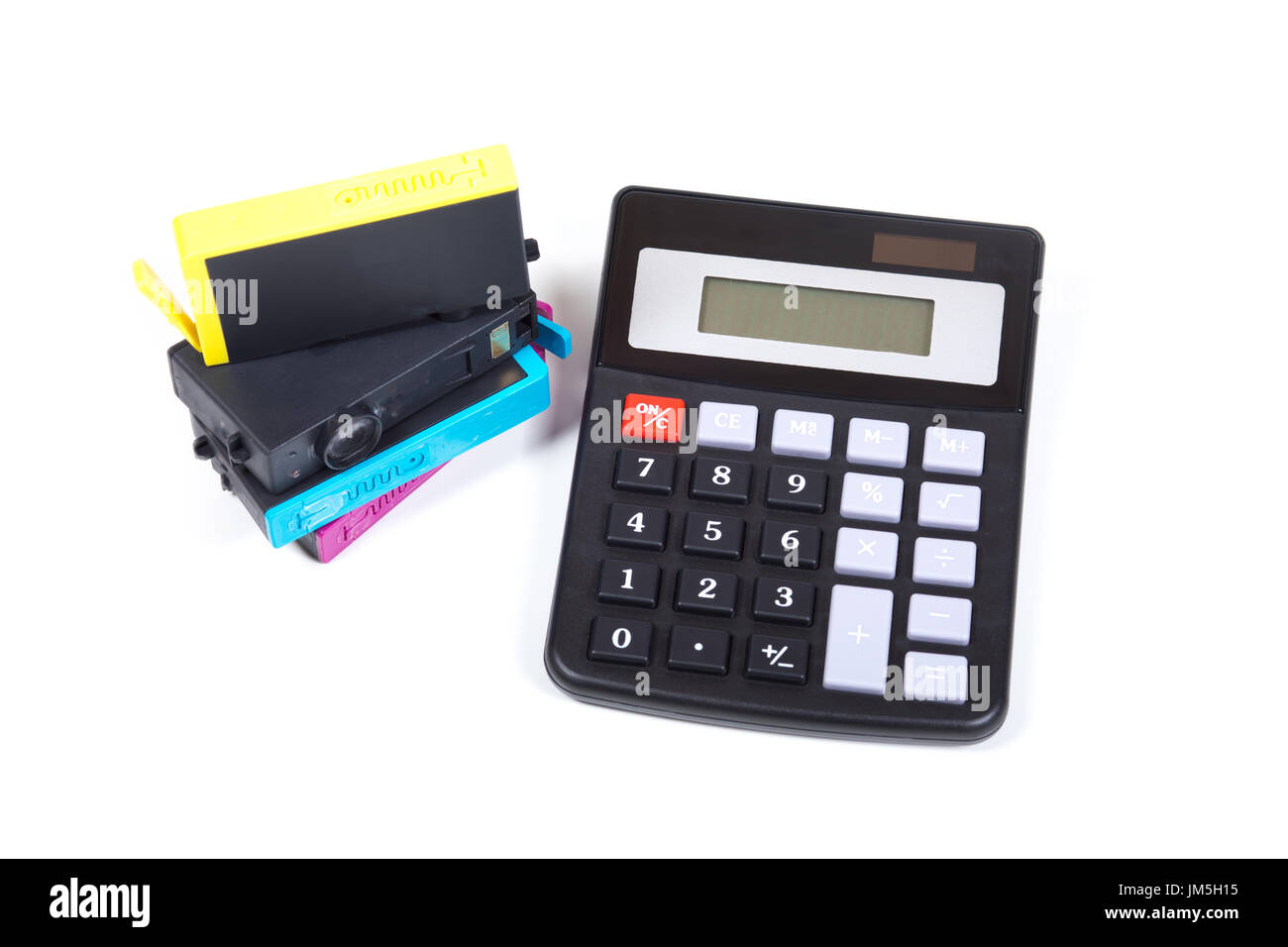 Pile de cartouches d'imprimante et d'encre de couleur noire au-dessus de la calculatrice simple isolé sur fond blanc, symbolisant les frais de consommables concept Banque D'Images