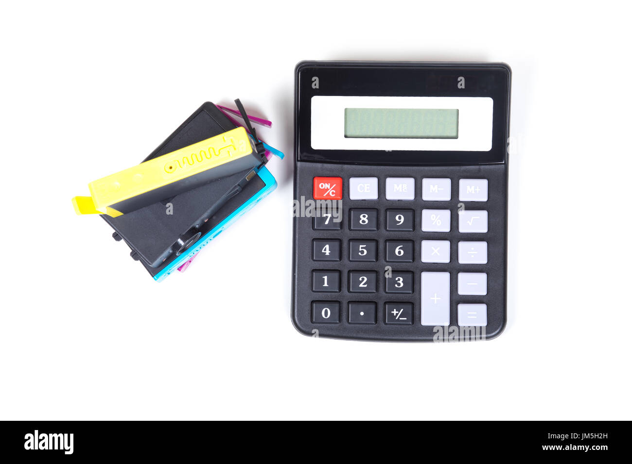 Pile de cartouches d'imprimante avec encre de couleur jaune sur le haut et au-dessus de la simple calculatrice noir isolé sur fond blanc, symbole consumab Banque D'Images