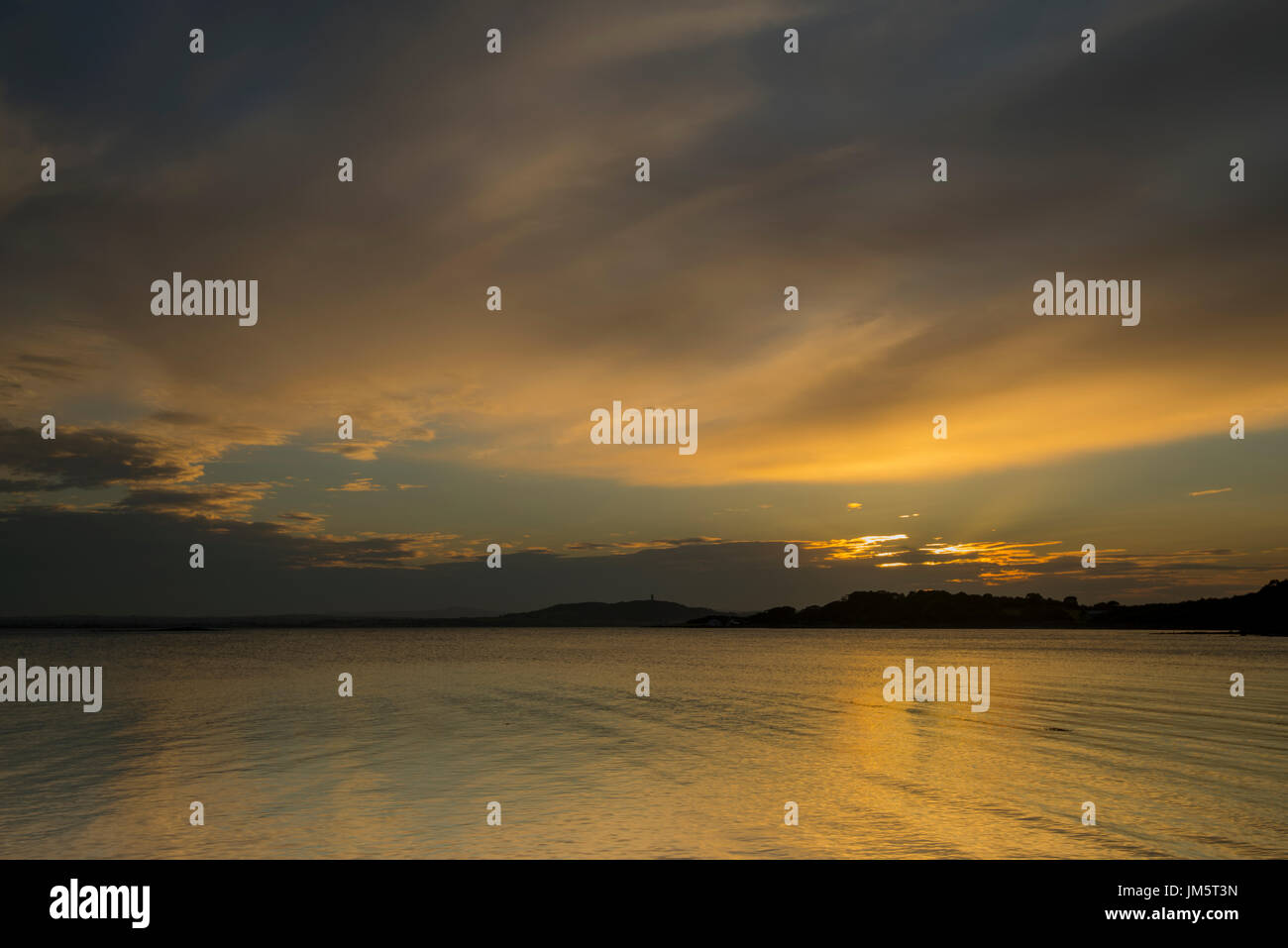 Coucher de soleil sur le Strangford Lough avec Scrabo Tower dans la distance, vu de l'Mountstewart Route à l'extérieur, Newtownards, Co N.Irlande en juillet 2017. Banque D'Images