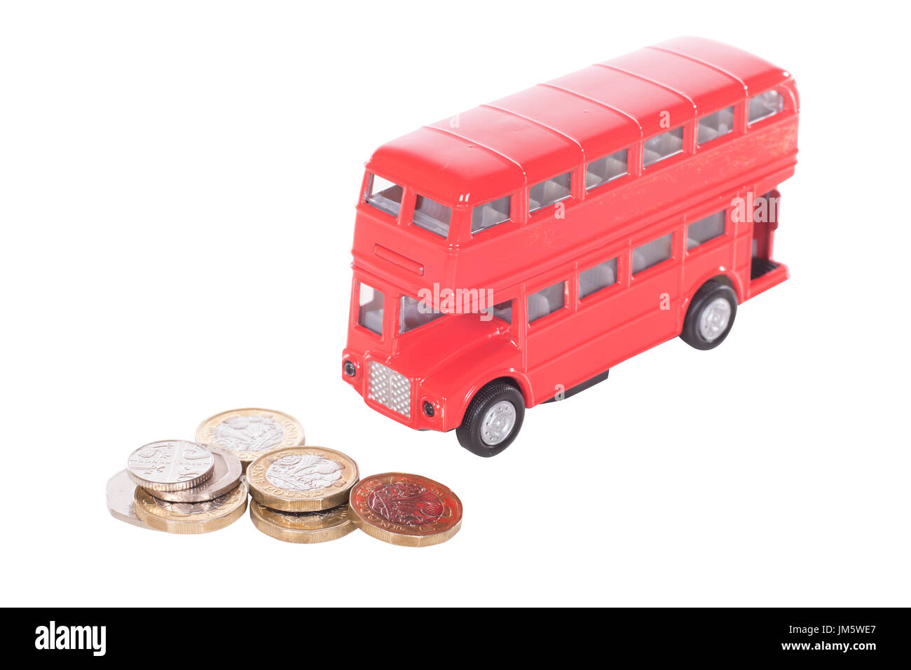 Pile de UK L'argent comptant dans les coins avec un modèle de bus à impériale rouge dans un concept du coût des transports publics et des déplacements Banque D'Images