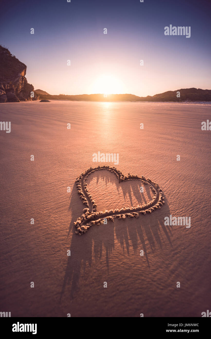 Coeur dessiné dans le sable de la plage. Concept de la Saint-Valentin. Banque D'Images
