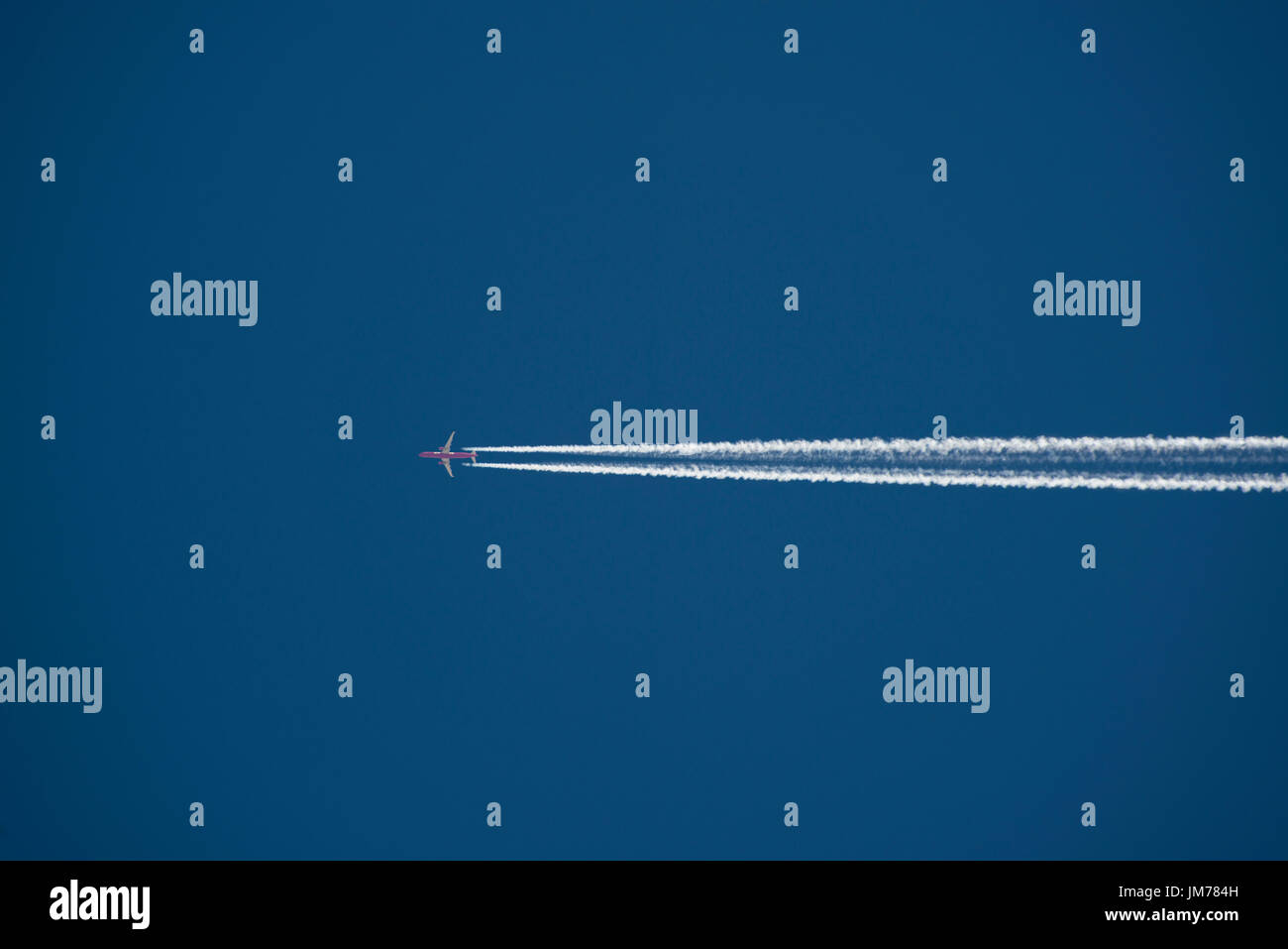 Voler haut dans le ciel, un avion - avion contre ciel bleu clair avec traînée de vapeur. crédit : lee ramsden / alamy Banque D'Images
