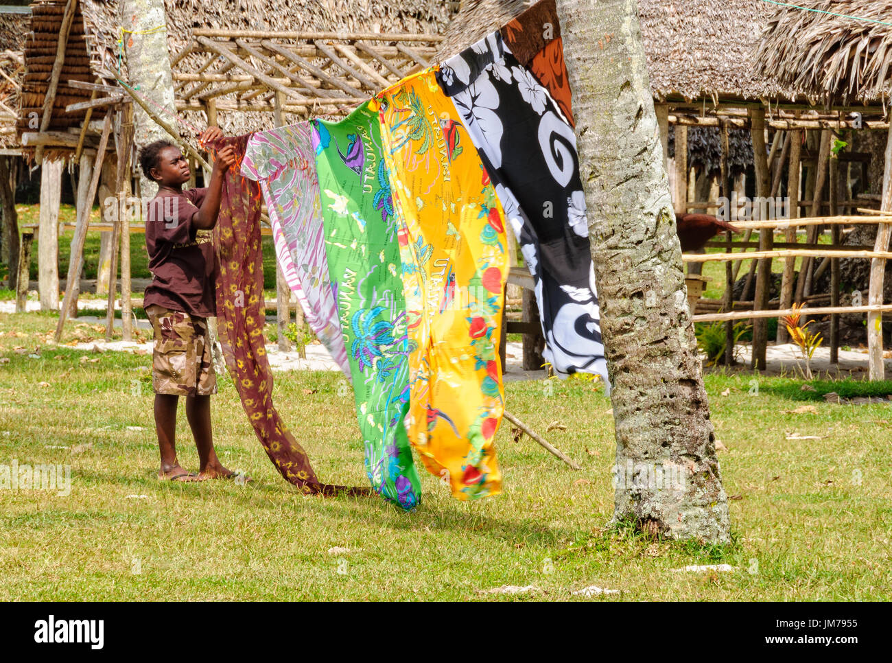 Un vendeur local avec des sarongs colorés voletant dans la brise à plage de Champagne - Espiritu Santo, Vanuatu Banque D'Images