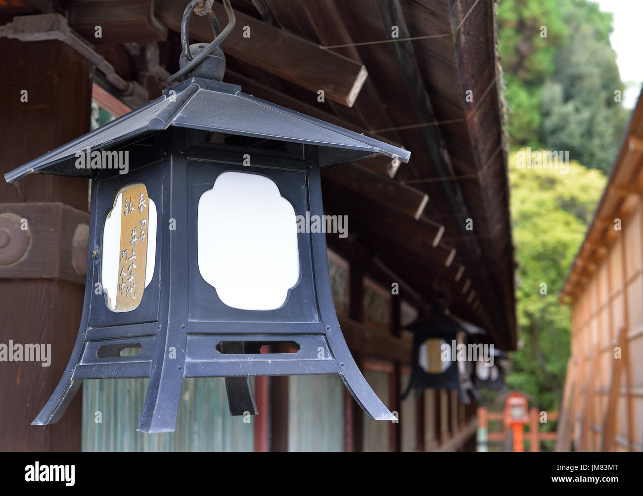 Une lanterne en métal est suspendue à partir de l'avant-toit du Sanctuaire Shinto Sanctuaire Yasaka jinja, Kyoto, Japon Banque D'Images