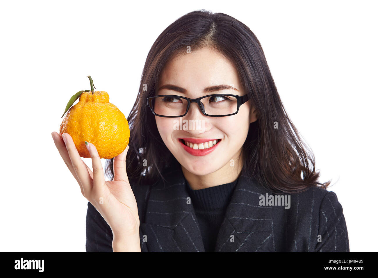 Young Asian Woman holding an ugli fruit, heureux et souriants, studio shot, isolé sur fond blanc. Banque D'Images Young Asian Woman holding an ugli fruit, heureux et souriants, studio shot, isolé sur fond blanc. Banque D'Images