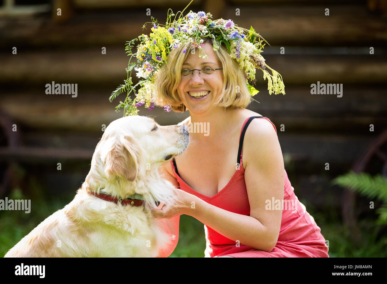 Jeune femme avec couronne sur sa tête et un chien, golden retriver Banque D'Images