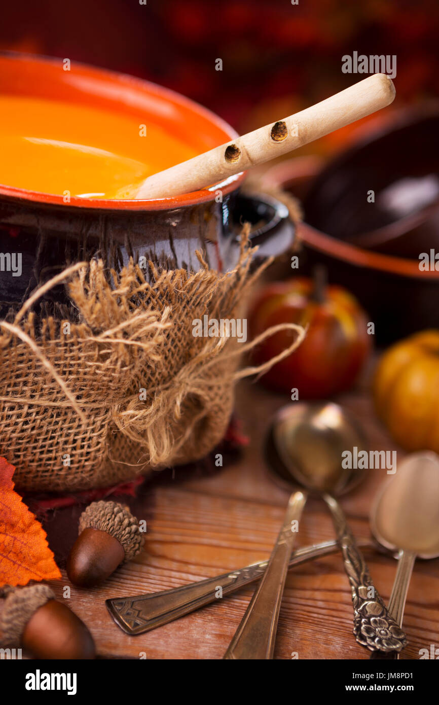 Un pot de crème maison soupe de potiron sur une table rustique avec des décorations d'automne. Banque D'Images
