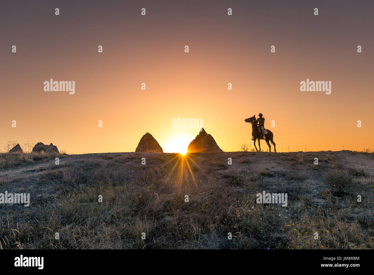 L'homme et le cheval silhouette sur le fond de vallée à la Cappadoce, Anatolie, Turquie.La grande attraction touristique de la Cappadoce meilleurs endroits pour voler avec Banque D'Images