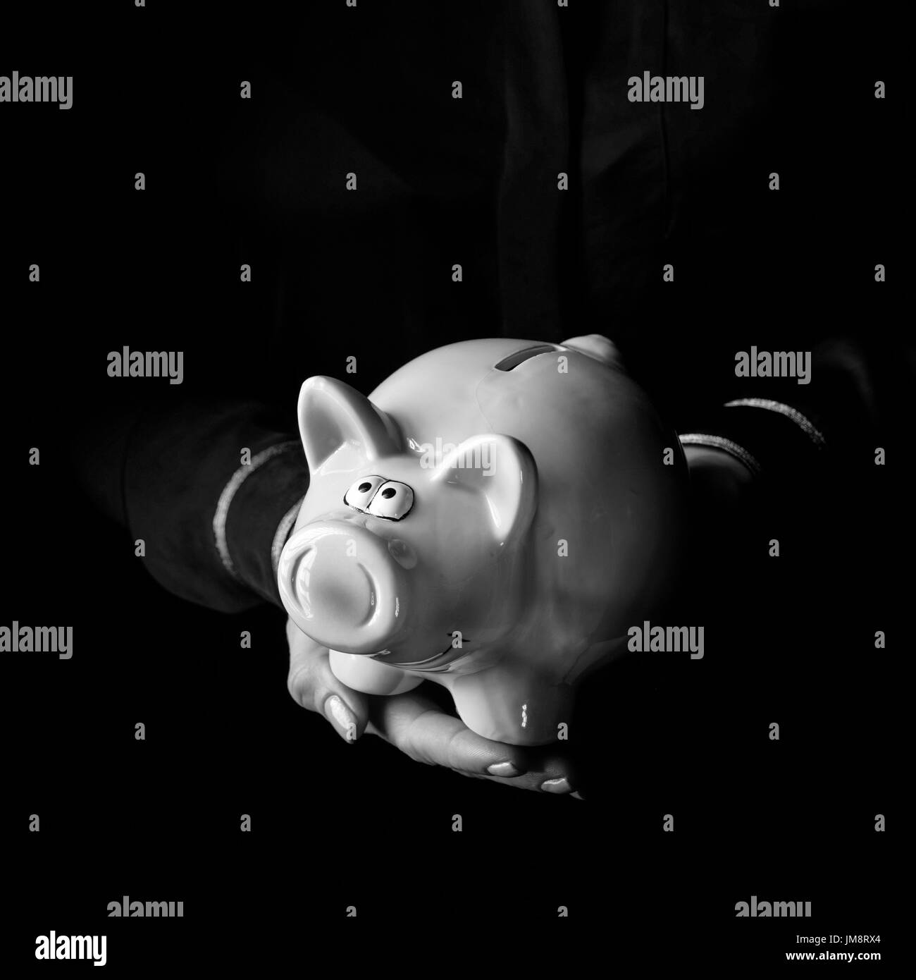 Mania noir. femme mains isolé sur fond noir montrant piggy bank Banque D'Images