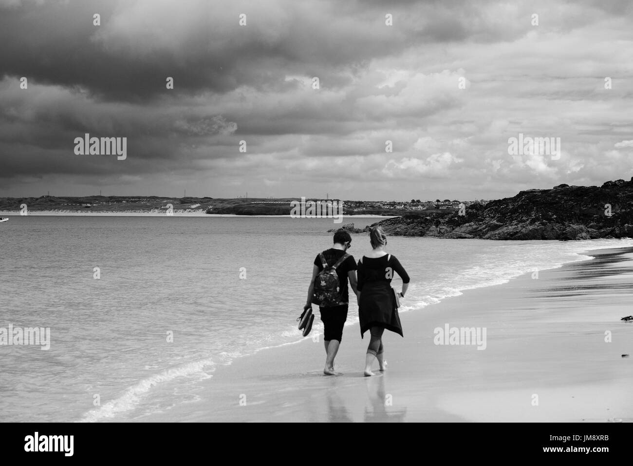 L'homme et la femme à marcher ensemble au bord de l'eau à la plage de Porthminster dans CornwallSt Ives, Cornwall Banque D'Images