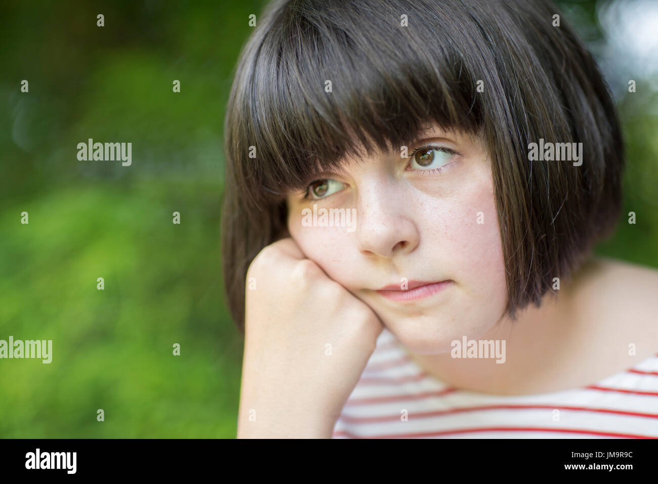 Close Up of malheureux Girl Sitting Outdoors Banque D'Images