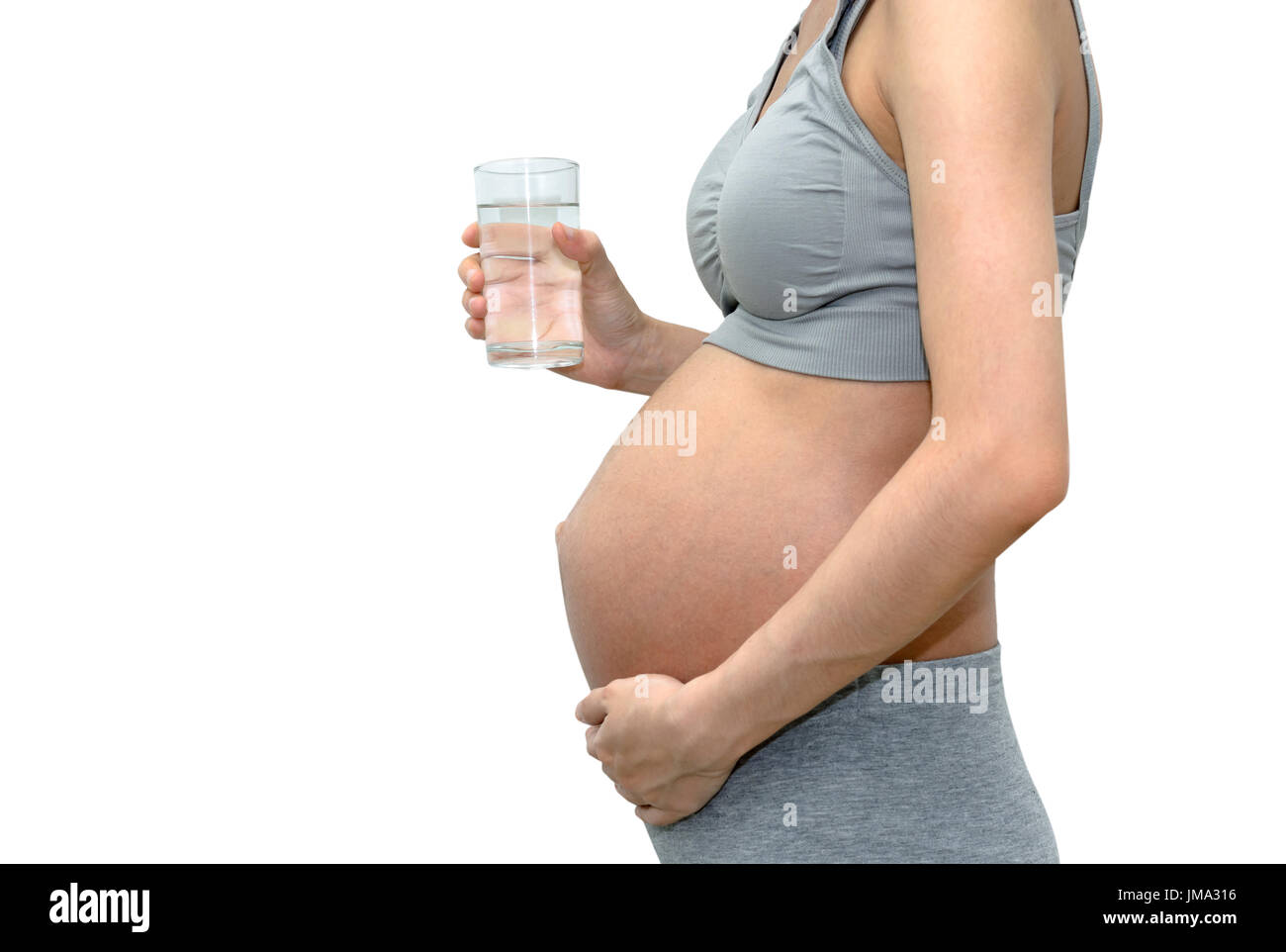 Close up of a cute pregnant belly femme avec un verre d'eau. Isolé sur fond blanc avec copie espace Banque D'Images