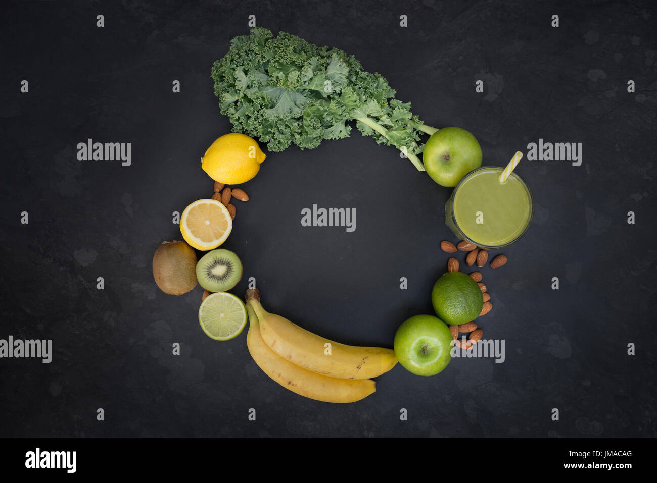 Le concept de vie saine avec un verre de smoothie vert entouré des fruits et légumes dans un cercle avec place pour le texte. Banque D'Images