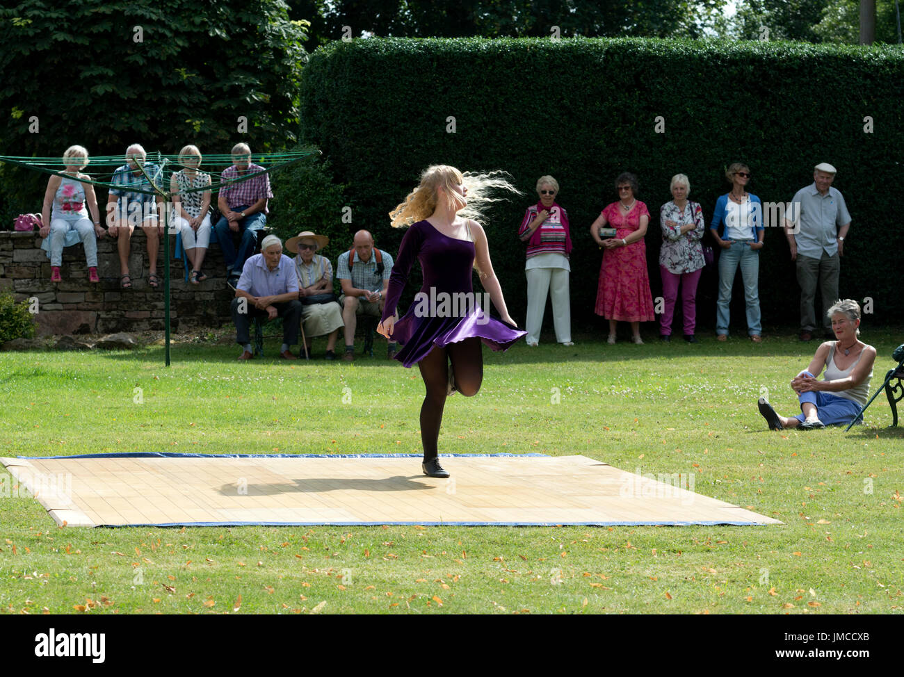 Une fille danser devant des gens dans un jardin, UK Banque D'Images