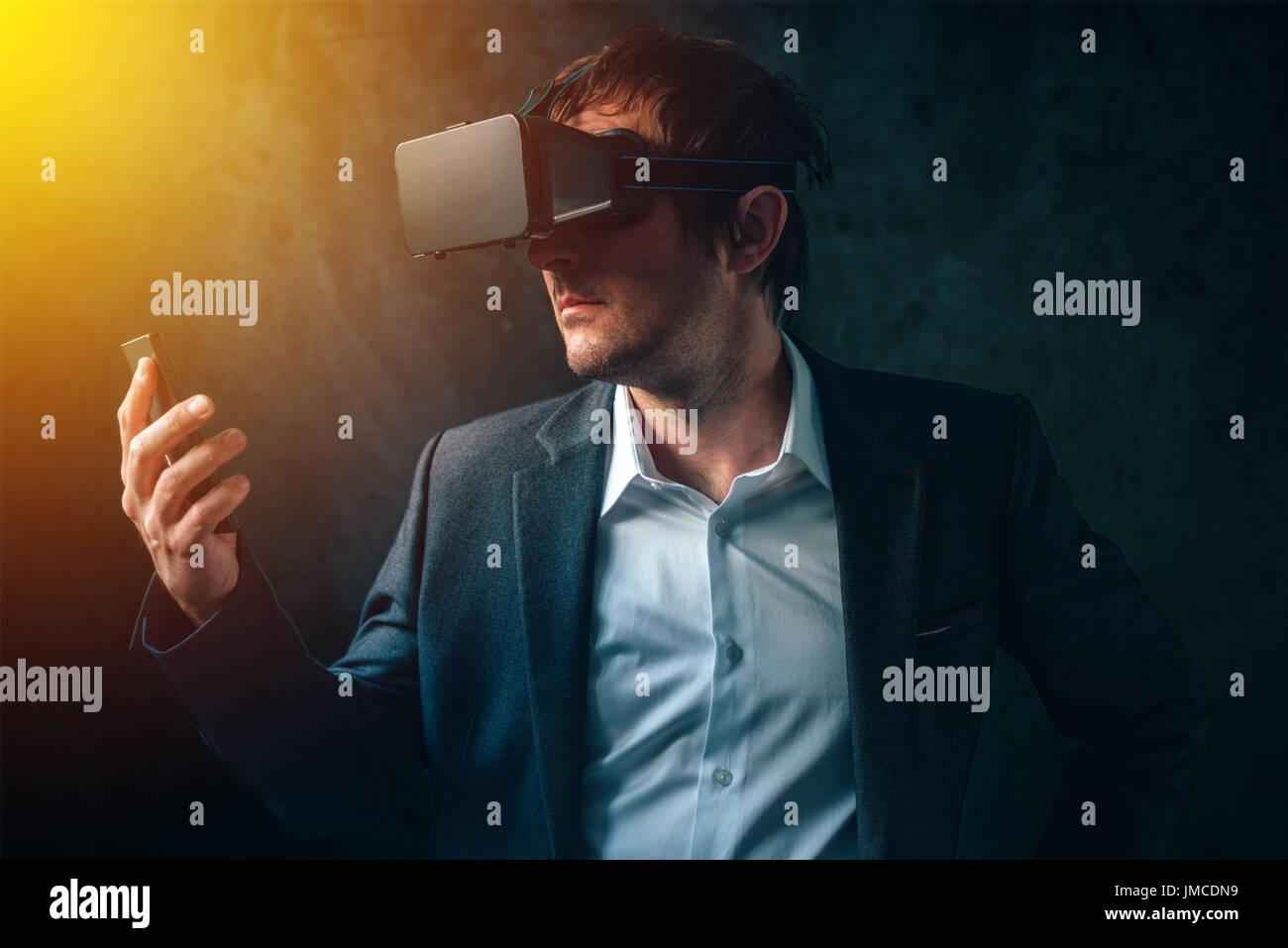 La réalité virtuelle et la technologie futuriste dans l'entreprise moderne, businessman avec casque VR et smart phone en utilisant de nouveaux gadgets haute technologie pour développer et gérer Banque D'Images