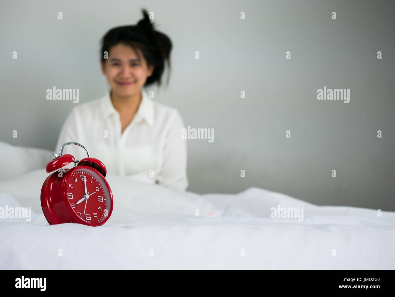 Les femmes asiatiques sourire réactiver. ar le matin sur le week-end s'asseoir sur le lit en chambre de luxe à vous détendre et concept de semaine Banque D'Images