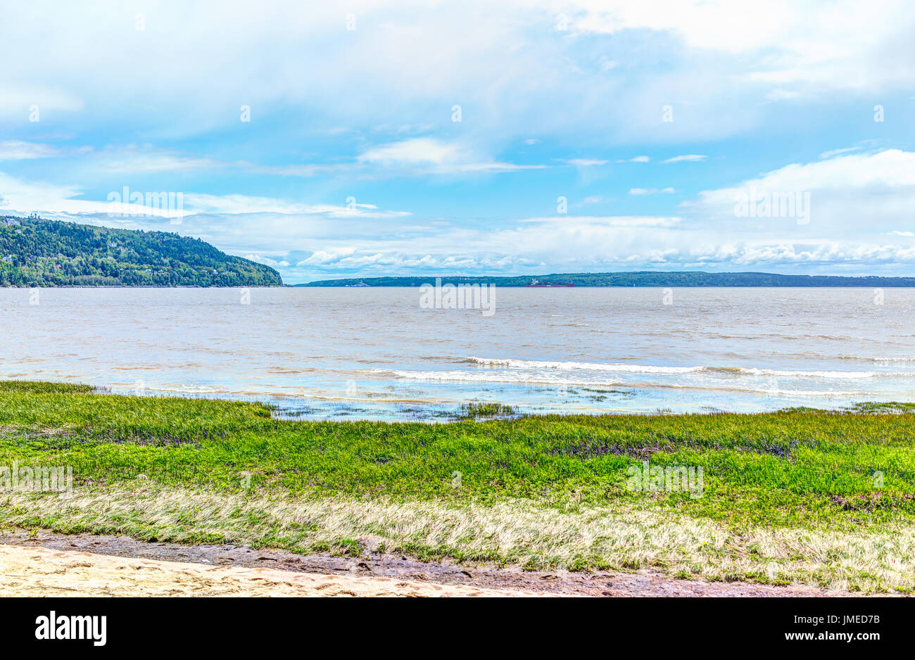 Baie-Saint-Paul au Québec, Canada et l'autre rive de la plage avec des vagues et de l'herbe verte Banque D'Images