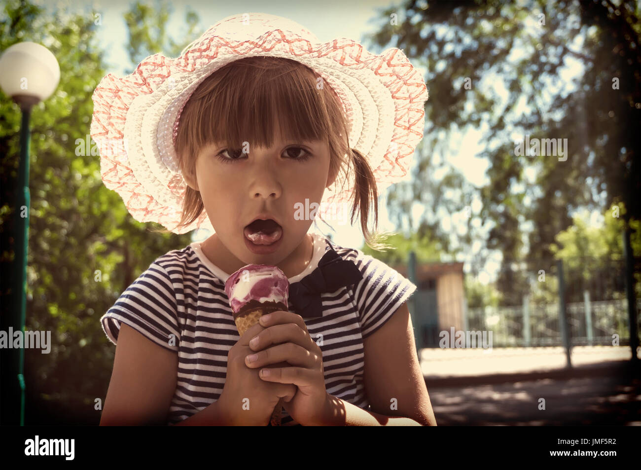 L'enfant mange de la crème glacée. retro photo tonifiant Banque D'Images