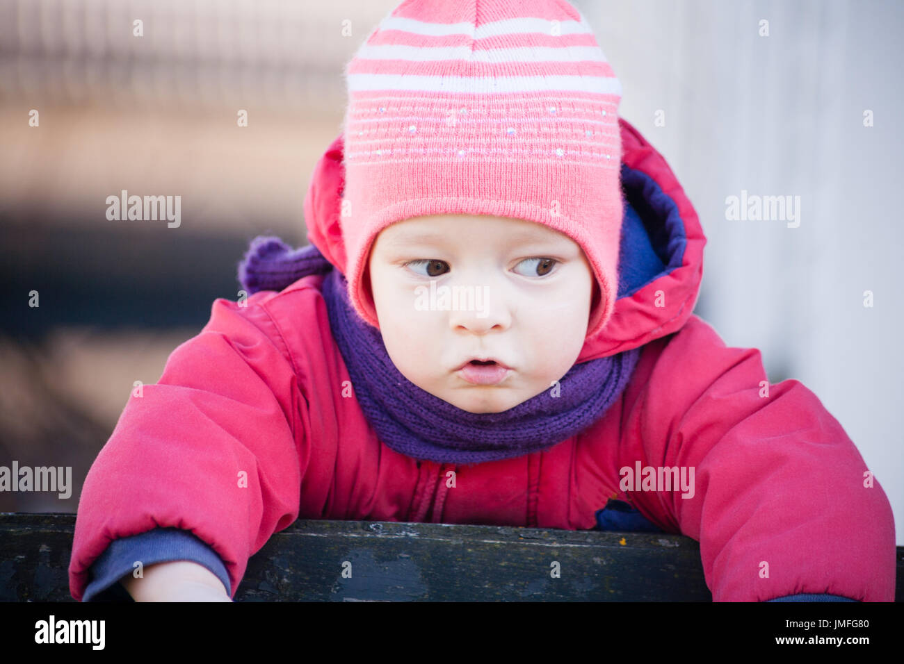 Brown Eyed Girl enfant est debout sur la barrière à gauche avec le cavalier rouge Banque D'Images