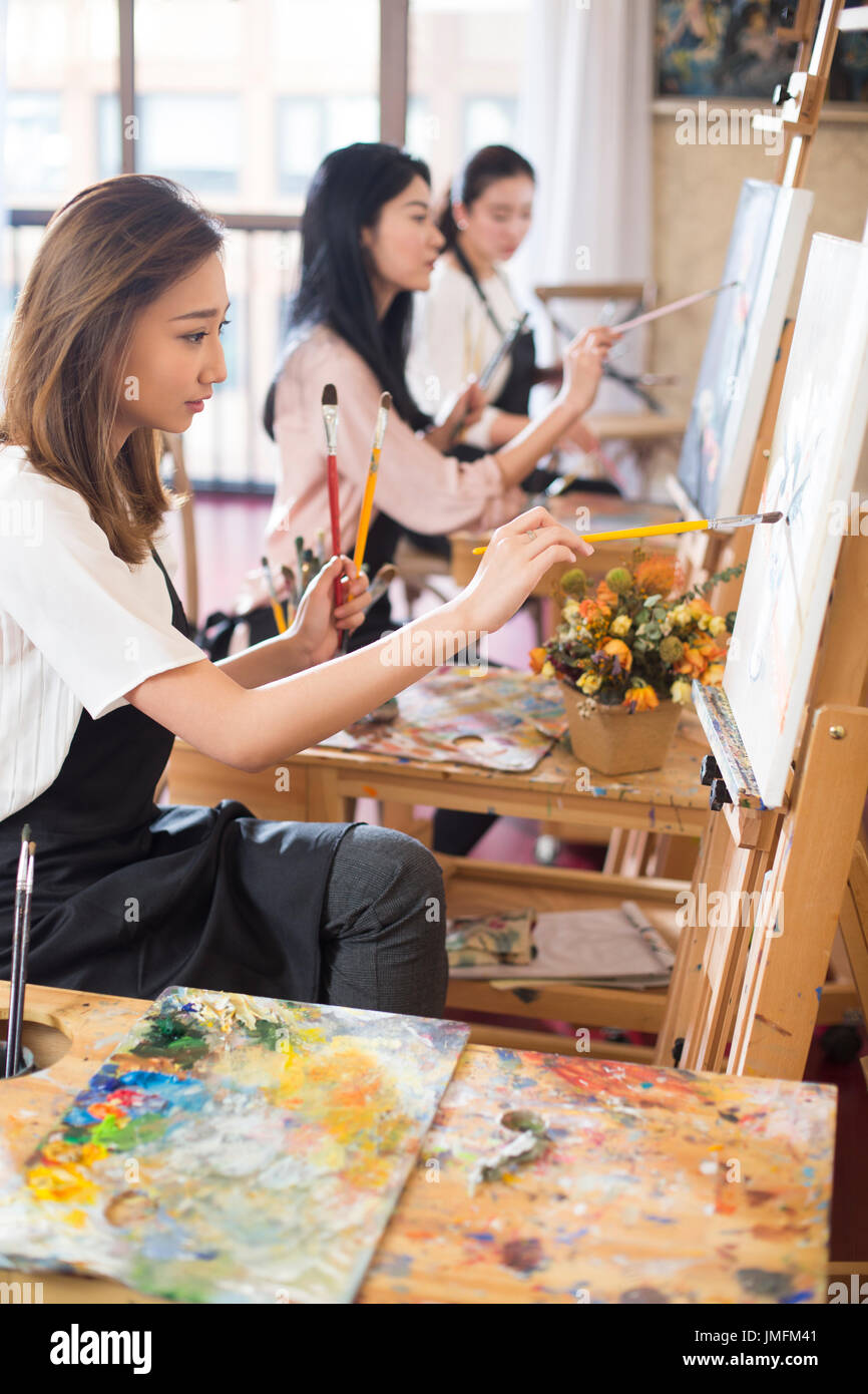 Les jeunes femmes la peinture en studio Banque D'Images