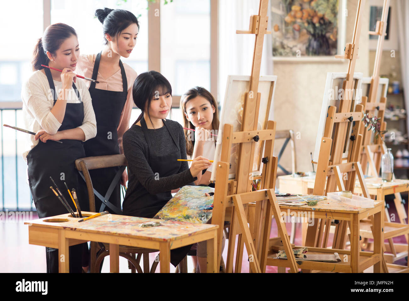 Professeur d'art avec les jeunes femmes en studio Banque D'Images