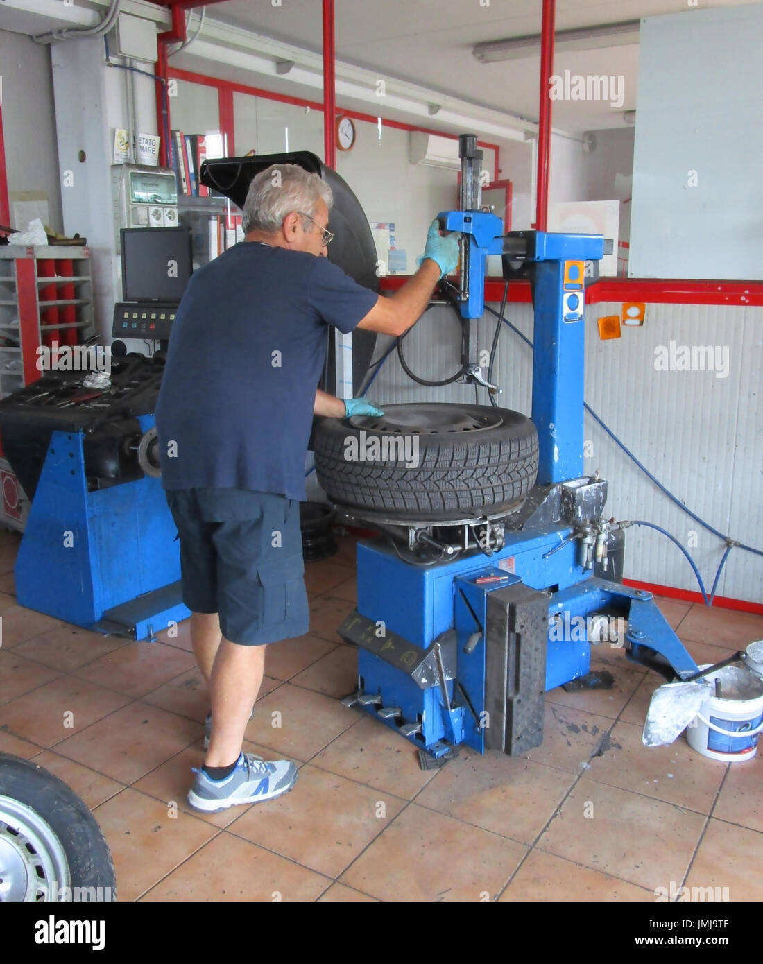 Le réparateur de pneus extrait le pneu de la jante Banque D'Images