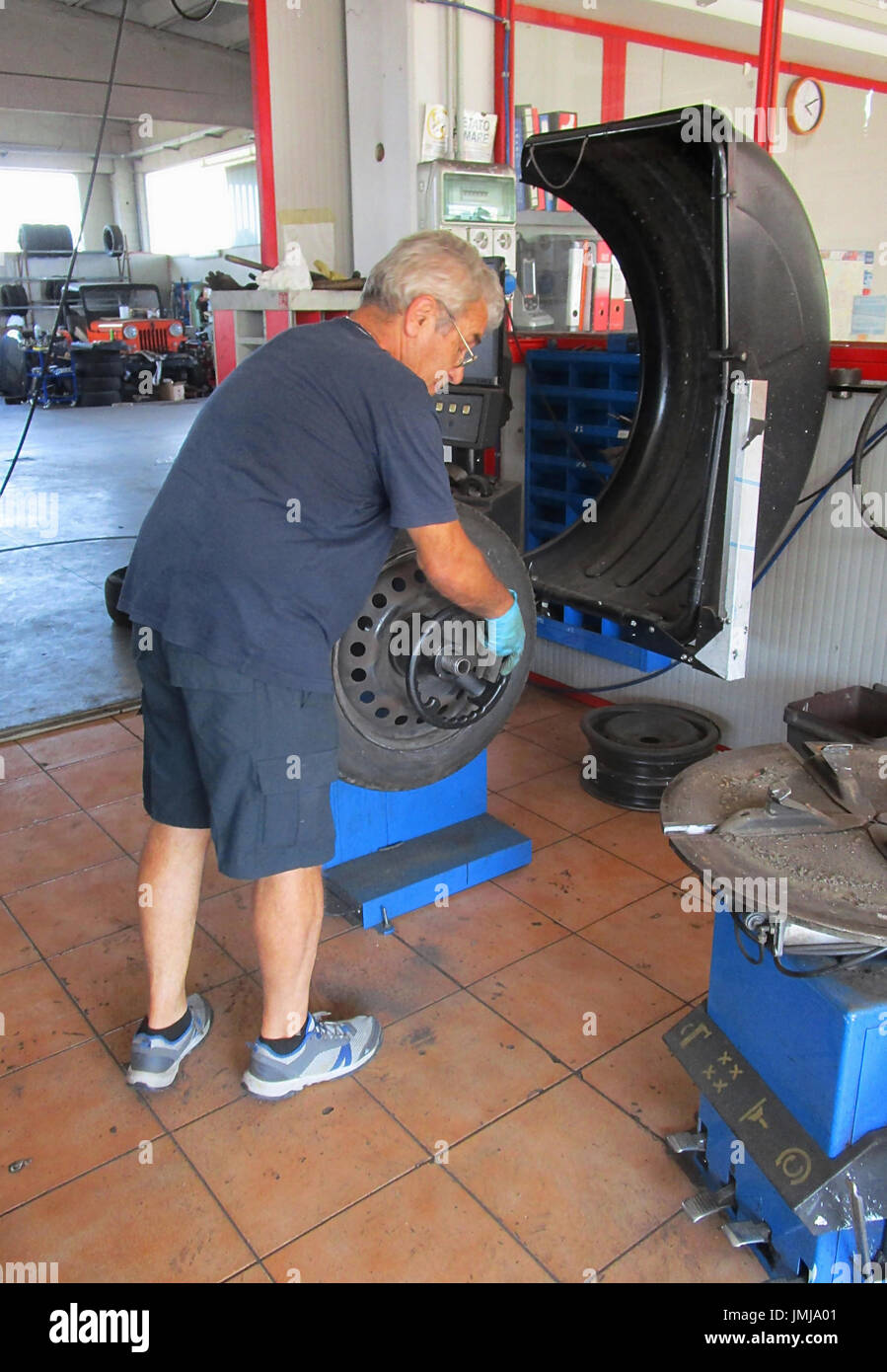 Le réparateur de pneus assure l'équilibre du nouveau pneu Banque D'Images