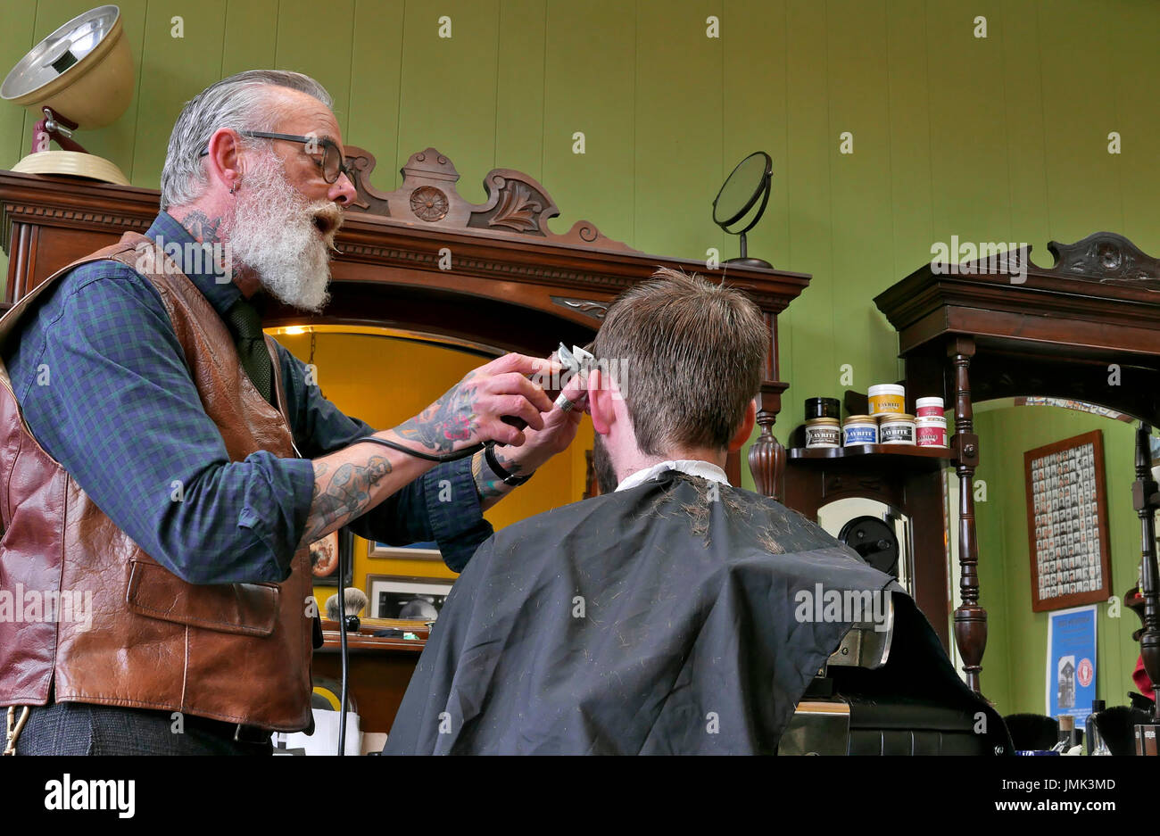 Coiffure traditionnelle avec des lunettes,barbe blanche et une coupe de cheveux clients tatouages Banque D'Images