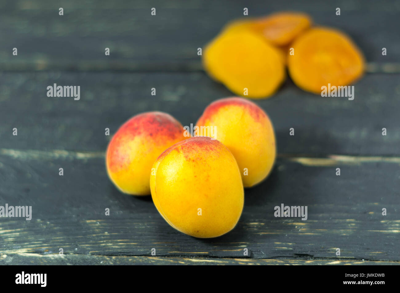 Abricot frais et abricots secs. Fond en bois sombre. En bonne santé. Banque D'Images