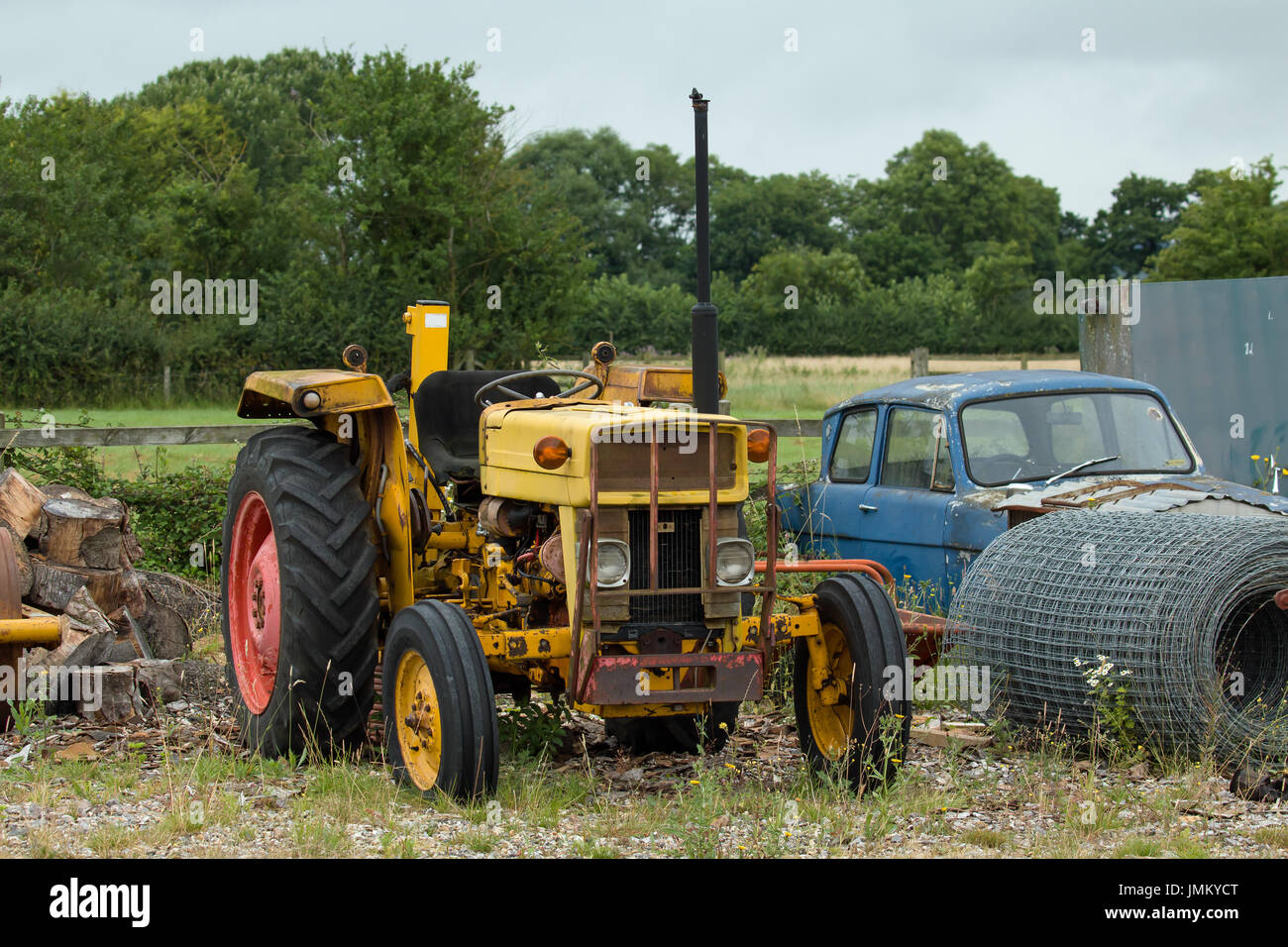 Ancienne, la rouille jaune, le tracteur sur la masse des déchets. Banque D'Images