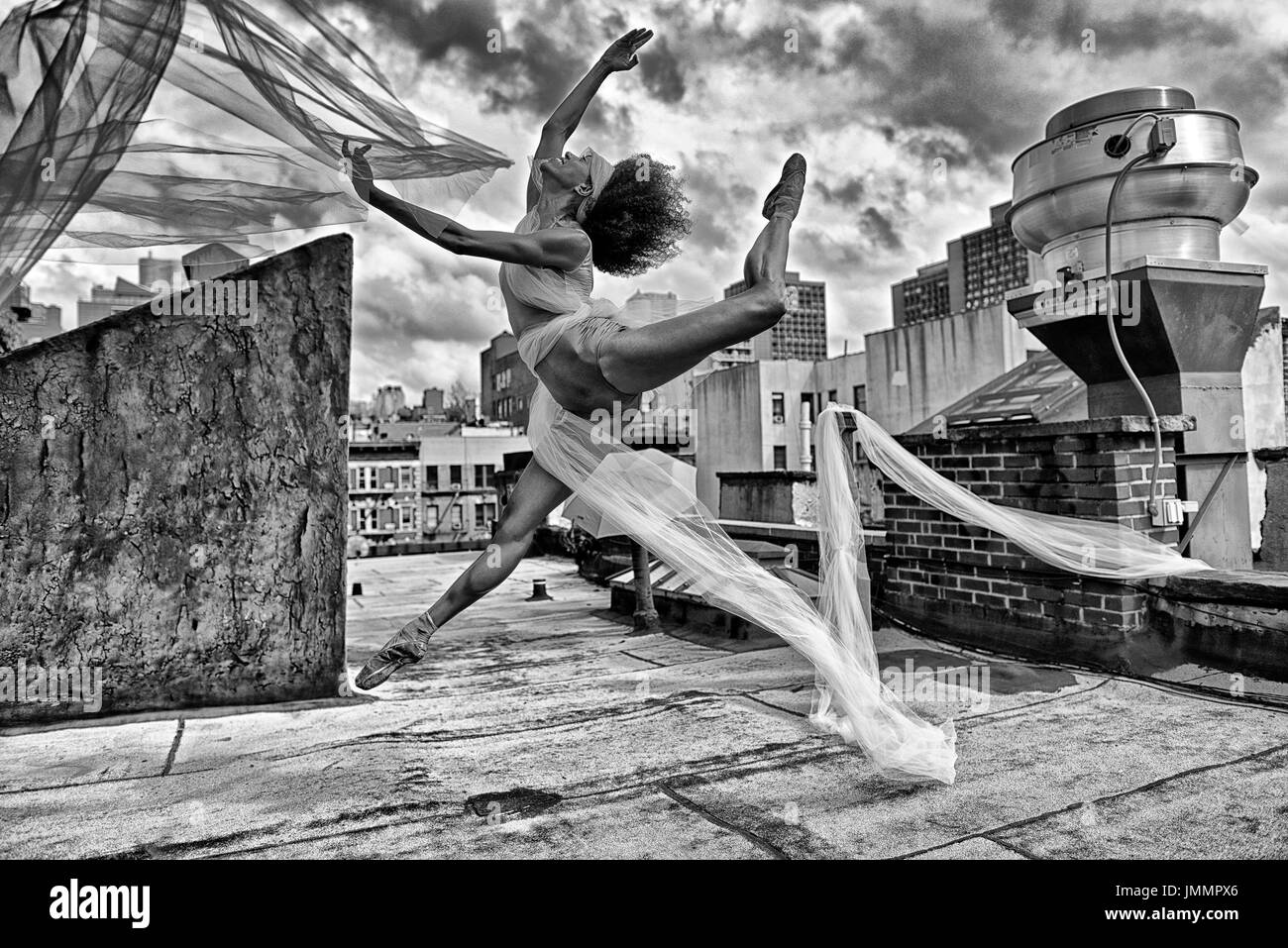 Dancer leaping sur un toit de New York. Banque D'Images