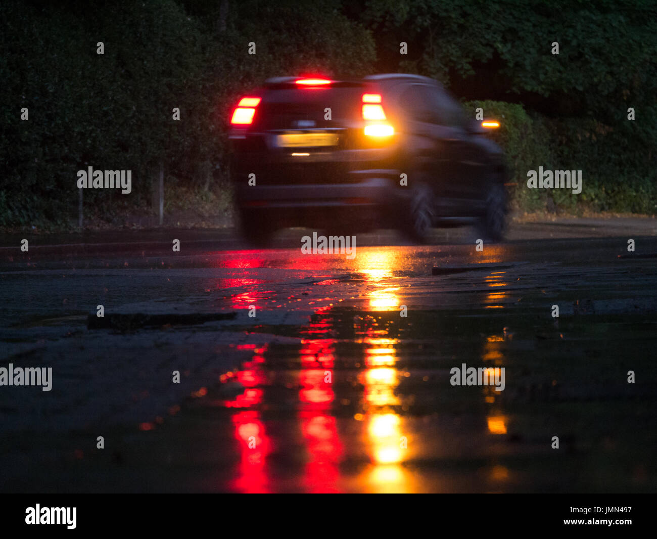 Voiture à la nuit avec des réflexions dans la pluie Banque D'Images