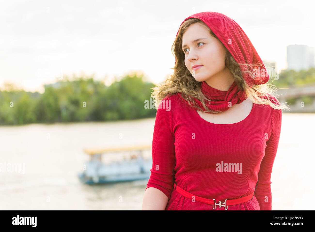 Jeune femme en robe rouge avec foulard sur tête posée par la pensée Rivière  Potomac pendant le coucher du soleil Photo Stock - Alamy